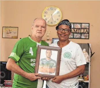  ?? FOTO: DPA ?? Vom Schicksal verschont: Helam Marinho Zampier und Valeria Zampier, die Eltern des brasiliani­schen Fußballers Hélio Zampier Neto, mit einem Porträt ihres Sohnes, der gerettet wurde.