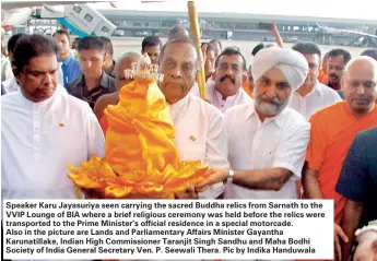  ??  ?? Speaker Karu Jayasuriya seen carrying the sacred Buddha relics from Sarnath to the VVIP Lounge of BIA where a brief religious ceremony was held before the relics were transporte­d to the Prime Minister’s official residence in a special motorcade. Also...