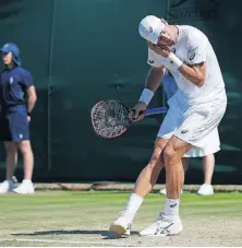  ?? [ALASTAIR GRANT/THE ASSOCIATED PRESS] ?? Steve Johnson of the United States fights off flying ants during Wednesday’s match against Moldova’s Radu Albot on day three at Wimbledon in London.