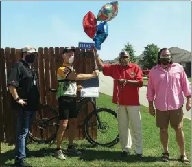  ?? (Special to the Democrat-Gazette/Nancy Raney) ?? Wearing his bicycling clothes, Bob Robinson accepts his award for Best Action Video from KQBK-FM host Tommy Street (from left), Fort Smith Mayor George McGill and Dr. Brandon Chase Goldsmith.