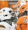  ?? BART BOATWRIGHT/CLEMSON ?? Clemson’s Trevor Lawrence goes chest to chest with Miami’s Gilbert Frierson last Saturday.