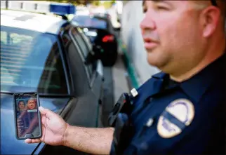  ?? SANDY HUFFAKER/THE NEW YORK TIMES / 2015 FILE ?? Officer John Rodrigues shows facial recognitio­n software on a tablet during his patrol in Chula Vista, Calif. Such technology is being widely used by police forces.