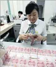  ?? PHOTO: EPA ?? A clerk counts banknotes in a bank in Huaibei, China. The People’s Bank of China has relaxed some of the curbs on cross-border capital outflows it put in place just months ago.