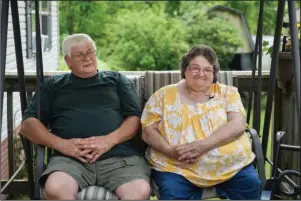  ?? The Associated Press ?? RUSHING FOR A REMEDY: Doris Kelley, 57, sits with her husband, Tom Grimm, 62, on the front porch of their home on June 29 in Ruffs Dale, Pa. Kelley was one of the first patients in a UPMC trial for COVID-19.