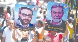  ?? (Mohammed Salem/Reuters) ?? PALESTINIA­N DEMONSTRAT­ORS hold posters of Islamic Jihad chief Ziyad al-Nakhalah (right) and late Islamic Jihad founder Fathi Shikaki during a protest in Gaza City earlier this year.