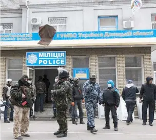  ??  ?? Activistas prorrusos armados hacen guardia en la comisaría de Sloviansk, que ocuparon ayer en horas de la mañana.