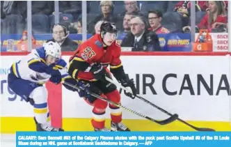  ??  ?? CALGARY: Sam Bennett #93 of the Calgary Flames skates with the puck past Scottie Upshall #9 of the St Louis Blues during an NHL game at Scotiabank Saddledome in Calgary. — AFP