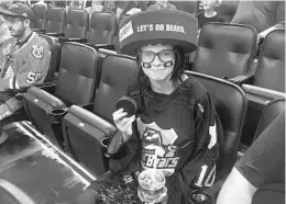  ?? PHOTOS BY STEPHEN RUIZ/STAFF ?? Makenzie Moore, a freshman at Lyman High School, holds the puck that Orlando Solar Bears right wing Darryl Bootland flipped to her after warmups before Sunday’s game.