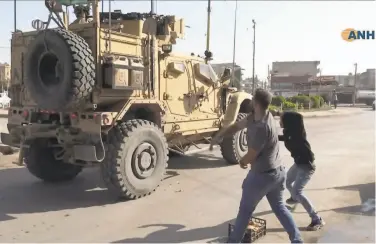  ?? Associated Press ?? Syrians angry over U.S. withdrawal hurl potatoes at American military vehicles in the town of Qamishli.