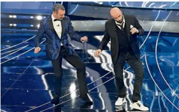  ?? FOTO: MARCO ALPOZZI/AP ?? John Travolta (re.) und Amadeus wagen während des Sanremo Musikfesti­vals ein Tänzchen.