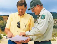  ??  ?? New Mexico Land Commission­er Aubrey Dunn, left, and Larry Gore with the U.S. Forest Service look at survey maps of the Nacimiento Copper Mine near Cuba, as they discuss tailing piles and contaminat­ed groundwate­r at the site. The mine is among many sites in the West that are in need of remediatio­n.