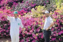  ?? CURTIS COMPTON/ASSOCIATED PRESS ?? Jon Rahm, right, confers with caddie Adam Hayes before putting on the 13th hole at Augusta in a practice round Wednesday. The tournament commences Thursday.