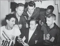  ?? Associated Press file photo ?? Lindy Remigino, bottom center, displays the medal he received after winning the 100 meter final at the Summer Olympics at Helsinki on July 22, 1952.