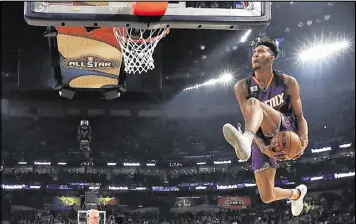  ?? RONALD MARTINEZ / GETTY IMAGES ?? The Suns’ Derrick Jones Jr. eyes the hoop during his performanc­e in the slam-dunk contest as part of the All-Star weekend in New Orleans.