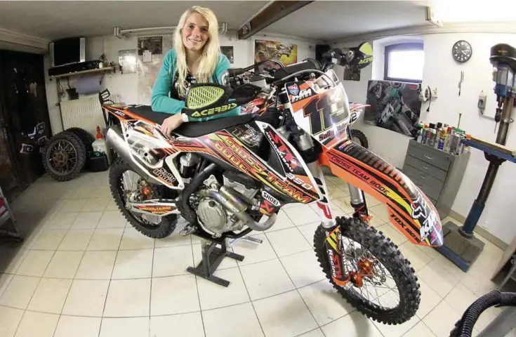  ?? Foto: Marcus Schulze ?? Sally Böde mit ihrer Maschine, einer KTM  SX-F, in der heimischen Werkstatt in Ruttersdor­f.