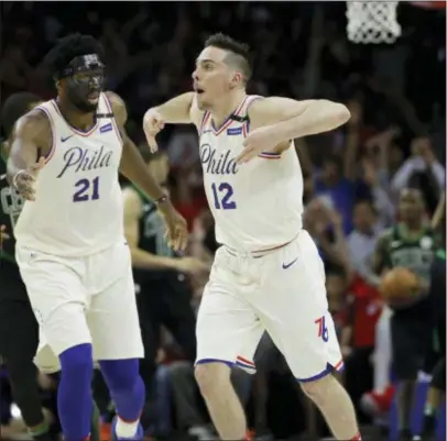  ?? MATT SLOCUM — THE ASSOCIATED PRESS ?? Philadelph­ia 76ers’ T.J. McConnell (12) and Joel Embiid celebrate during the second half of Game 4 of an NBA basketball second-round playoff series against the Boston Celtics, Monday in Philadelph­ia. Philadelph­ia won 103-92.