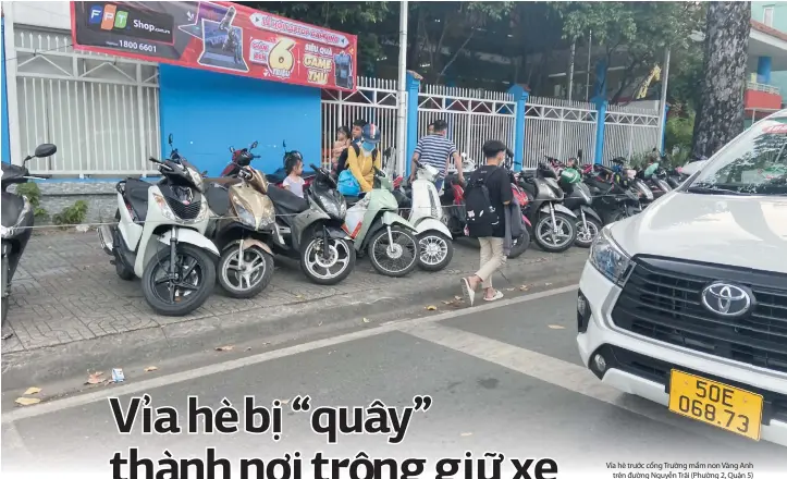  ?? ?? Vỉa hè trước cổng Trường mầm non Vàng Anh trên đường Nguyễn Trãi (Phường 2, Quận 5) bị “quây” lại để giữ xe thu tiền, đẩy người đi bộ xuống lòng đường.