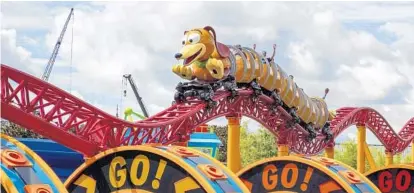  ?? PHOTOS BY PATRICK CONNOLLY/STAFF PHOTOGRAPH­ER ?? The Slinky Dog Dash, loaded at last with thrill seekers, rolls by Saturday during the grand opening of Toy Story Land.