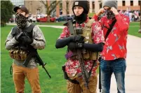  ?? JEFF KOWALSKY AFP/GETTY IMAGES ?? Armed protesters in Hawaiian shirts on April 30 take part in a demonstrat­ion outside the state capitol in Lansing, Mich.