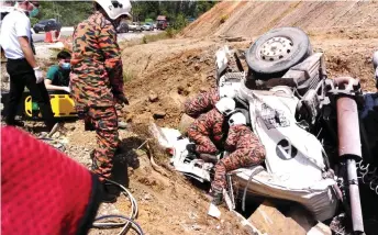  ??  ?? Bomba personnel in the process of extricatin­g the driver from the wreckage.