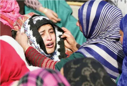  ??  ?? A woman consoles a relative of a Kashmiri policeman during his funeral north of Srinagar, Indian-administer­ed Kashmir, on Saturday. (AP)