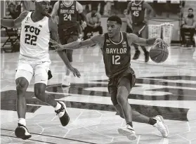  ?? RichardW. Rodriguez / Associated Press ?? TCU’s RJ Nembhard, left, defends as Baylor’s Jared Butler drives to the basket during Saturday’s game in FortWorth. The Bears improved to 11-0 with the win.