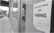  ??  ?? A “now hiring” sign hangs in the window of a Chinese restaurant in downtown Fargo, N.D.