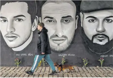  ?? Armando Babani / AFP ?? Un home passa davant un mural que recorda les víctimes dels tirotejos de Hanau, ahir.