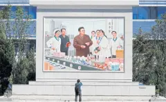  ??  ?? LEFT A cameraman films a painting depicting Kim Jong-il on a factory tour.