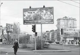  ?? John MacFougall AFP/Getty Images ?? A BILLBOARD in Donetsk, Ukraine, in 2015 includes rebel leader Alexander Zakharchen­ko, center. He said the city would be the capital of the new country.