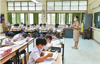  ?? AFP-Yonhap ?? Students at Suanlumpin­ee School in Bangkok wear face masks while singing the national anthem amid traffic pollution outside their open classroom windows, Bangkok, Thailand, Jan. 22.