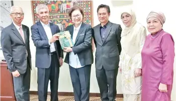  ??  ?? Christina (third from left) receiving a book on Yayasan Sabah from Jamalul Kiram. Third from right is William.