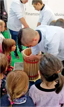  ??  ?? Eager children watching apples being crushed to produce juice.