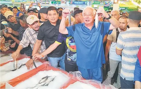  ??  ?? Najib checks on the fish at the fresh produce section at the hypermarke­t.