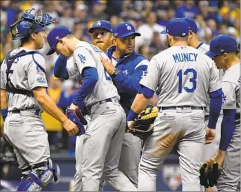  ?? Wally Skalij Los Angeles Times ?? MANAGER DAVE ROBERTS, center, leads the Dodgers into Game 1 of the World Series on Tuesday at Boston, where he is remembered for helping the Red Sox stun the New York Yankees in the 2004 ALCS.