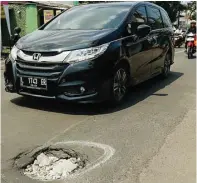  ?? ALFIAN RIZAL/JAWA POS ?? BERBAHAYA: Lubang di Jalan Raya Kalirungku­t kemarin.