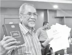  ??  ?? Wan Junaidi holds up a copy of the Federal Constituti­on.