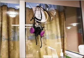  ?? ?? A nurse’s respirator hangs outside the room of a COVID-19 patient at OHSU Hospital in Portland. Hospital administra­tors have sought a balance between curtailing elective procedures and maintainin­g them to ensure that delays in care don’t endanger patients.