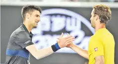  ?? — AFP photo ?? Serbia's Novak Djokovic (L) shakes hands as he celebrates after victory over Spain's Albert Ramos Viñolas in their men's singles third round match on day six of the Australian Open tennis tournament in Melbourne on January 20, 2018.