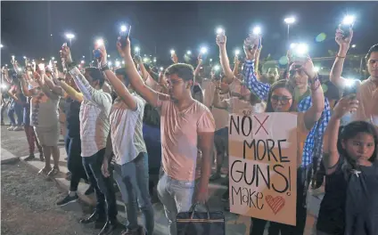  ?? REUTERS ?? Mourners take part in a vigil near the border fence between Mexico and the US after a mass shooting at a Walmart store in El Paso, Texas on Saturday.