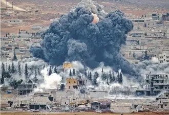  ?? THE ASSOCIATED PRESS ?? Smoke rises from the Syrian city of Kobani, following an airstrike by the U. S.- led coalition. More than 10,000 ISIL fighters have been killed by airstrikes in nine months, according to a U. S. official.