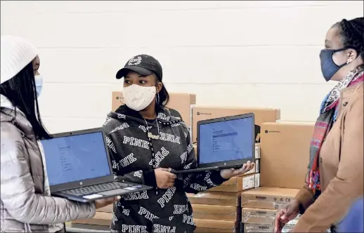  ?? Will Waldron / Times Union ?? City School District of Albany Superinten­dent, Kaweeda G. Adams, right, talks to Albany High School students Jorlenys Valverde, left, and Amani Santos, center, after the pair were presented with laptops from the Workforce Developmen­t Institute on Tuesday in Albany.