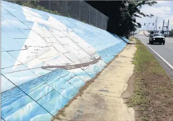  ?? KEVIN MCGILL/AP ?? A mural along Africatown Boulevard in Mobile, Alabama, depicts Clotilda, the last ship that brought slaves to the U.S.