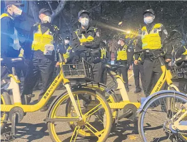  ?? REUTERS ?? Police officers stand guard during a demonstrat­ion against Covid-19 curbs following the deadly Urumqi fire, in Shanghai, China on Sunday.