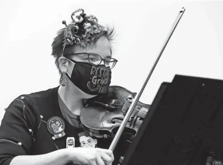  ?? BARBARA J. PERENIC/COLUMBUS DISPATCH ?? Dr. Sheila Santa plays the violin with a string quartet she started called Santa Presents Music at Stanton’s Sheet Music in Downtown Columbus on Tuesday. The group formed during the pandemic to reach people with music during quarantine. The performanc­e was broadcast on Facebook Live and other social media platforms.