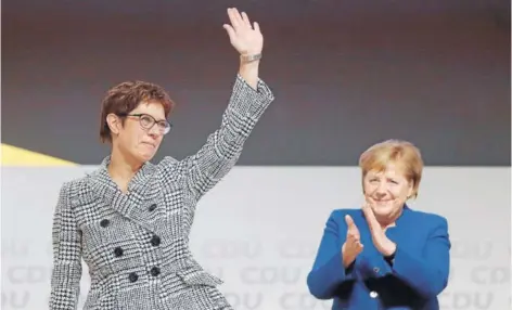  ??  ?? ► Kramp-Karrenbaue­r, secundada por Merkel, tras ser elegida ayer como líder de la CDU, en Hamburgo.