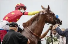  ?? Victor J. Blue/The New York Times ?? Jockey Mike Smith pours water on Justify to cool him off after winning the Belmont Stakes at Belmont Park in Elmont, N.Y., on June 9, 2018. Justify won at Belmont and garnered the Triple Crown in 2018, but a month before the Kentucky Derby, the horse failed a drug test that could have ended that campaign before it began.