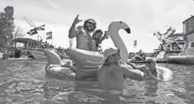  ?? AP ?? Revelers congregate around Gull Island during the Jobbie Nooner on Friday.