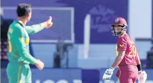  ?? AP ?? West Indies’ Nicholas Pooran (right) looks back to South African bowler Keshav Maharaj after he was dismissed during their ICC Men’s T20 World Cup match in Dubai, United Arab Emirates, on Tuesday.