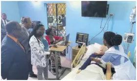  ?? ?? United States Ambassador to Jamaica N Nick Perry (left) looks on as second-year NCU nursing student Pakyce Peterkin utilises a mannequin at the Hyacinth Chen School of Nursing.